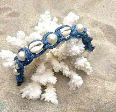 Cowrie & Pearl collar, Royal Blue, styled with coral on the sand